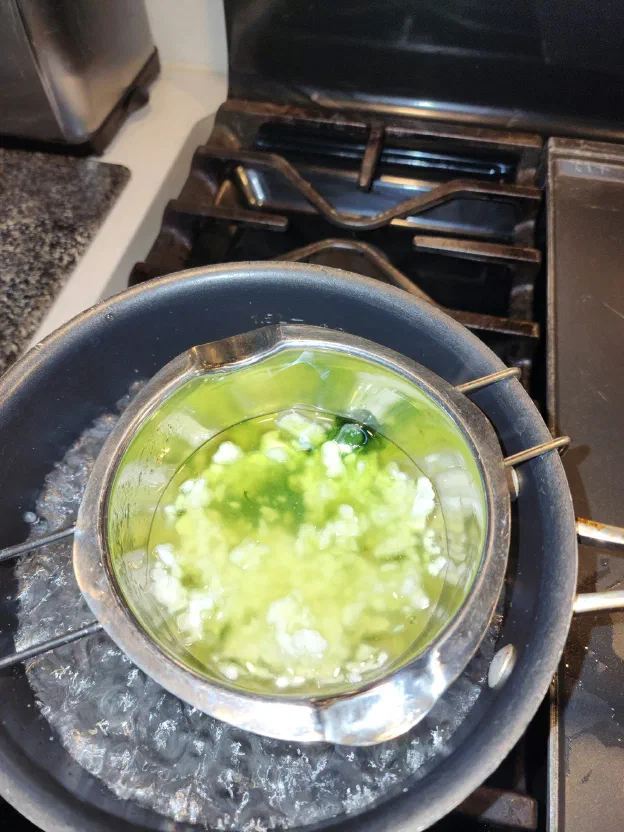 The beeswax and the color chips are melted in a double boiler...