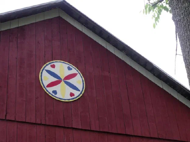 A painted hex sign on the gable of a Pennsylvania barn