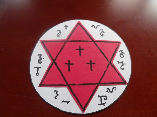 The completed protection talisman — red hexagram and three crosses on a white disc ringed with sigils