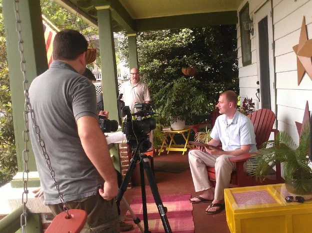 A documentary crew filming an interview on a Pennsylvania farmhouse porch