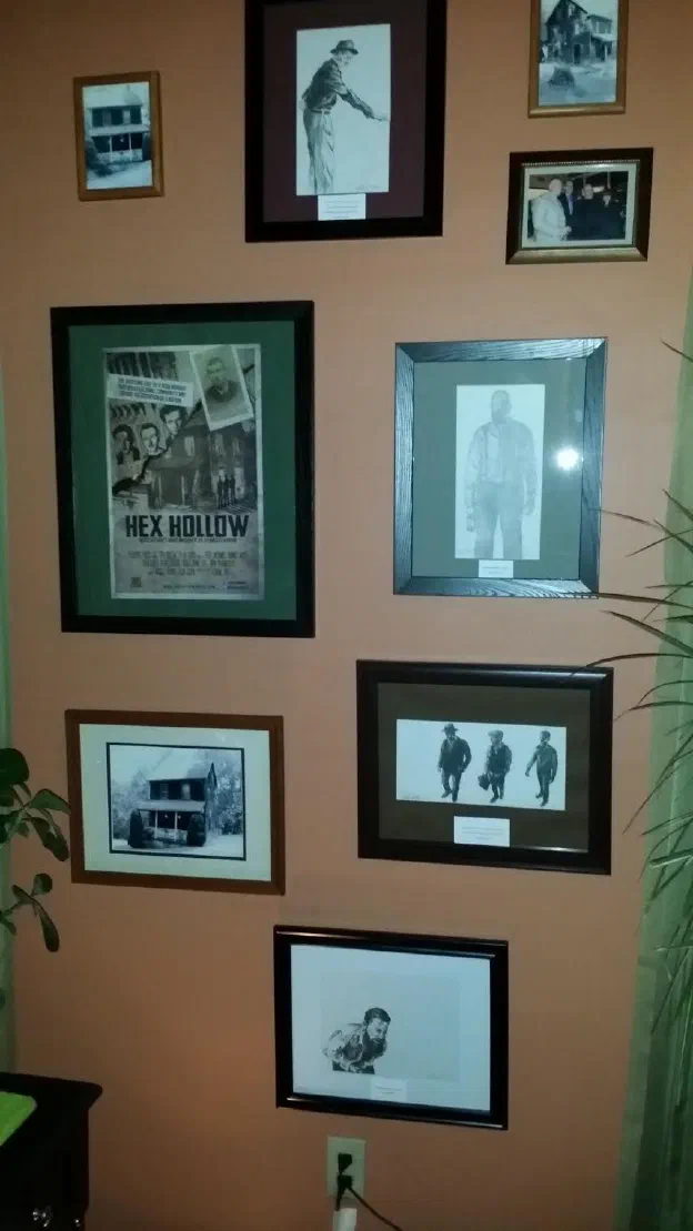 A wall hung with framed photographs and clippings about the Rehmeyer case