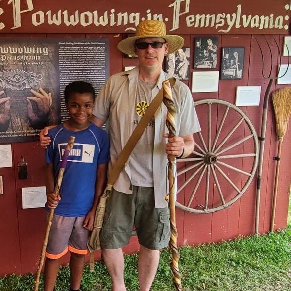 Robert Phoenix and his son at a Pennsylvania German folklife event, each holding a hand-carved staff
